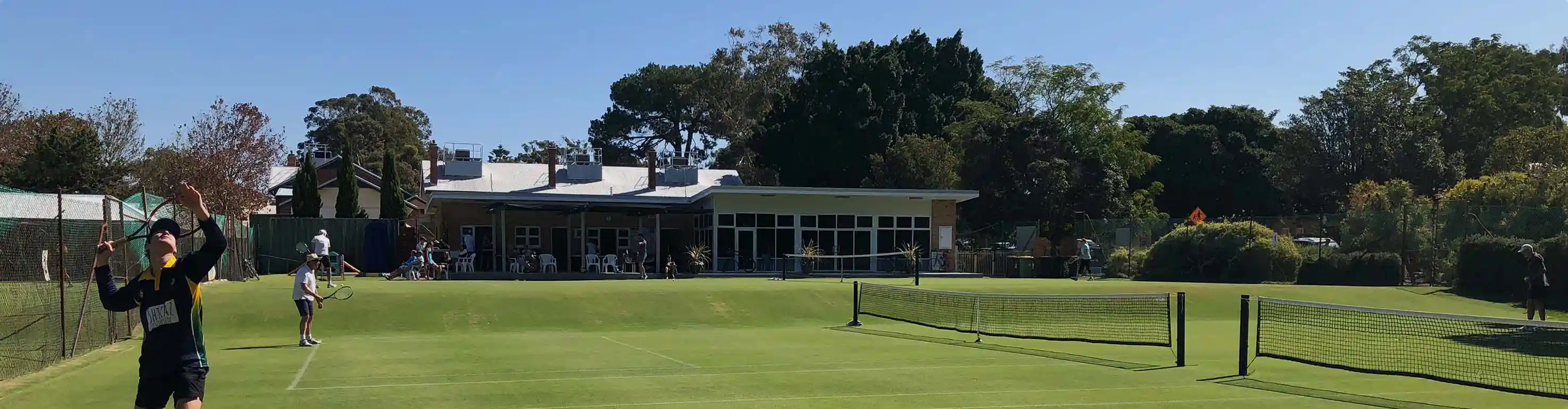 OPTC grass courts with clubhouse in background